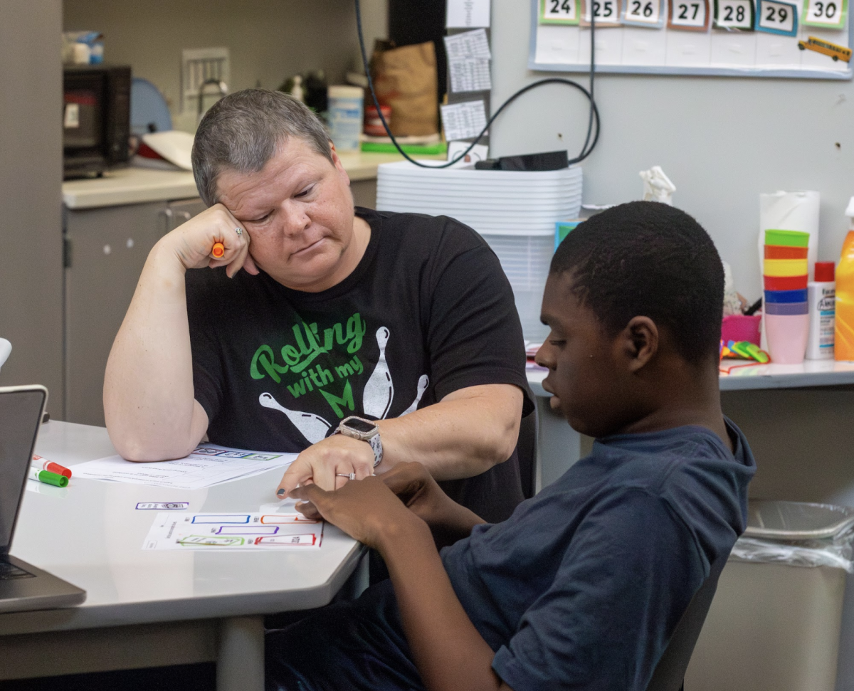 Erin Campbell, the founder of the Free State Autism Program, works with a student on an activity. 